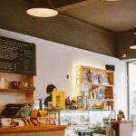 Warm and inviting café interior featuring a counter, displayed menu board, and various food items.