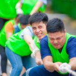Energetic team building tug of war event outdoors in Hanoi, Vietnam.